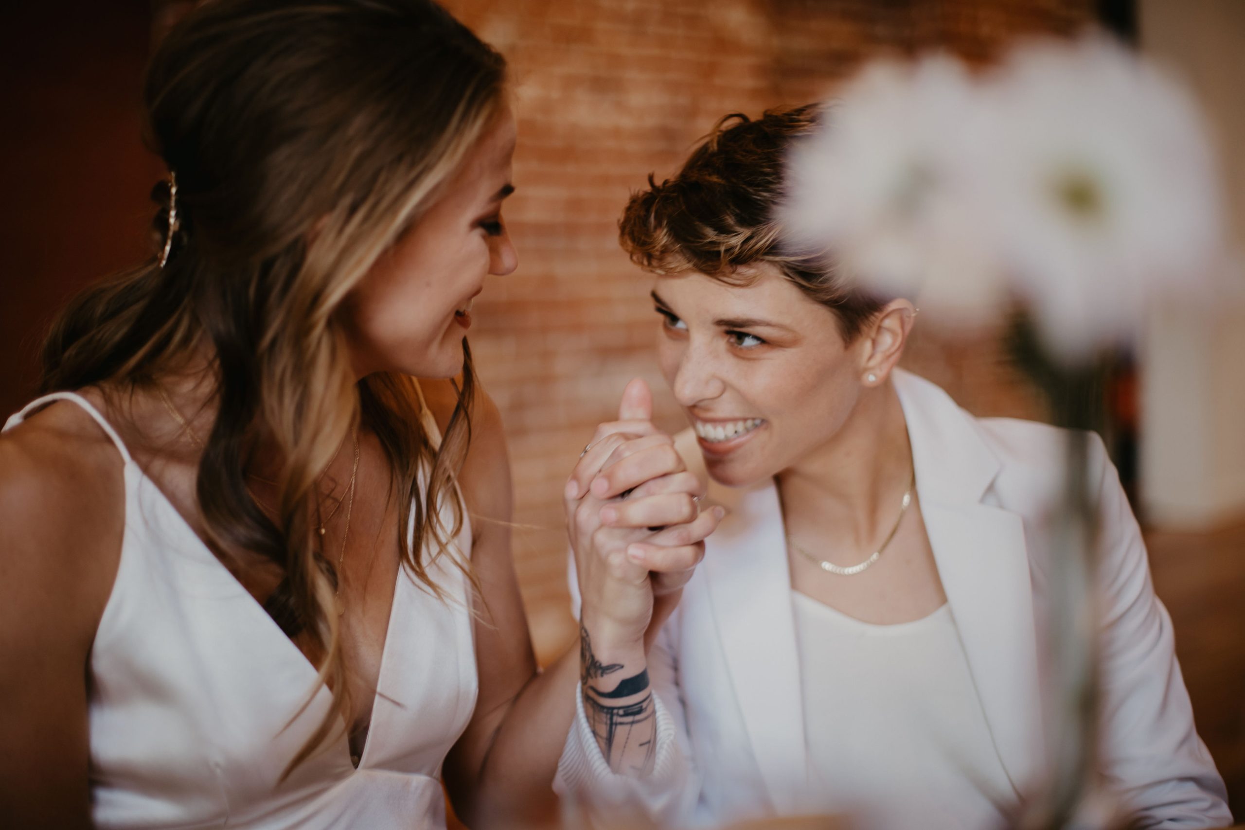 Couple holding hands, looking at each other, and smiling 