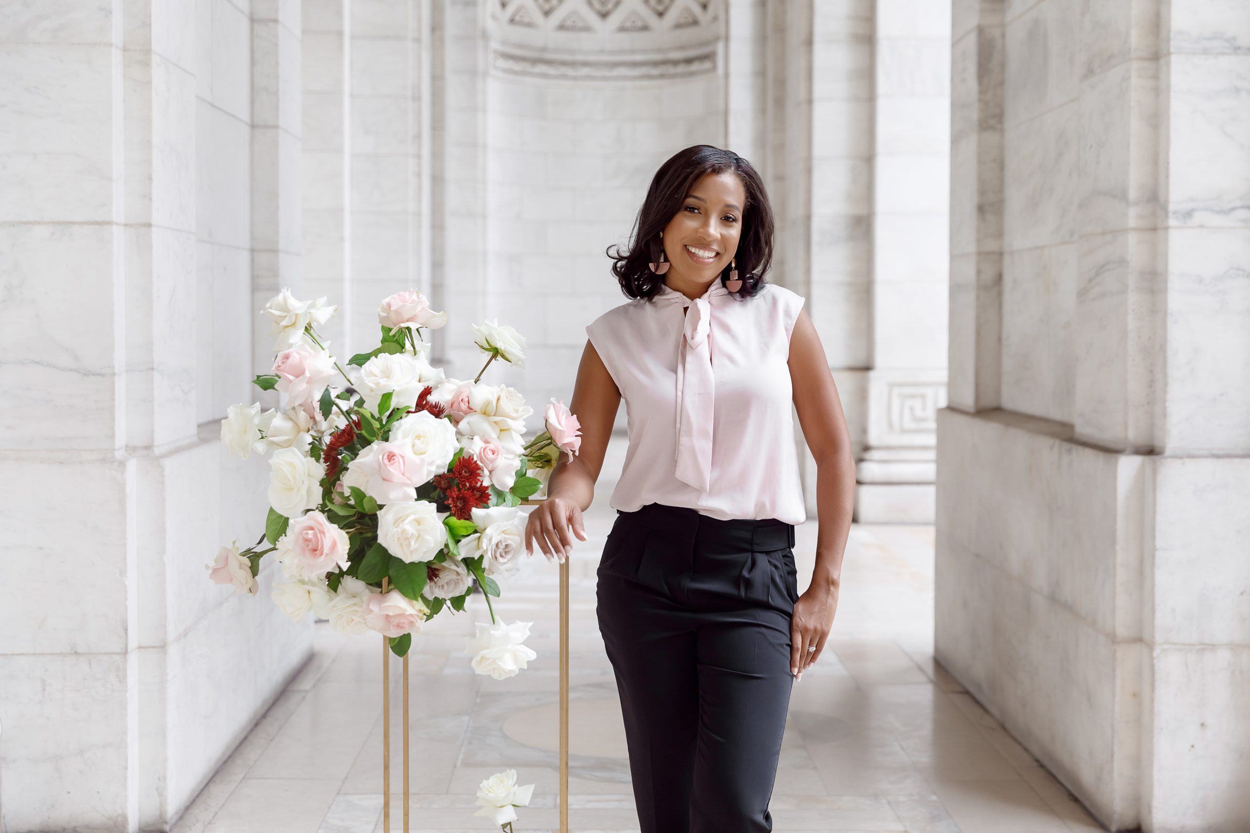 Simone Vega with floral bouquet in hallway of venue